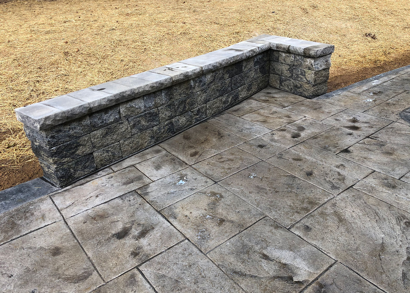 Amanda S stamped concrete patio with stone wall detail by ASRE