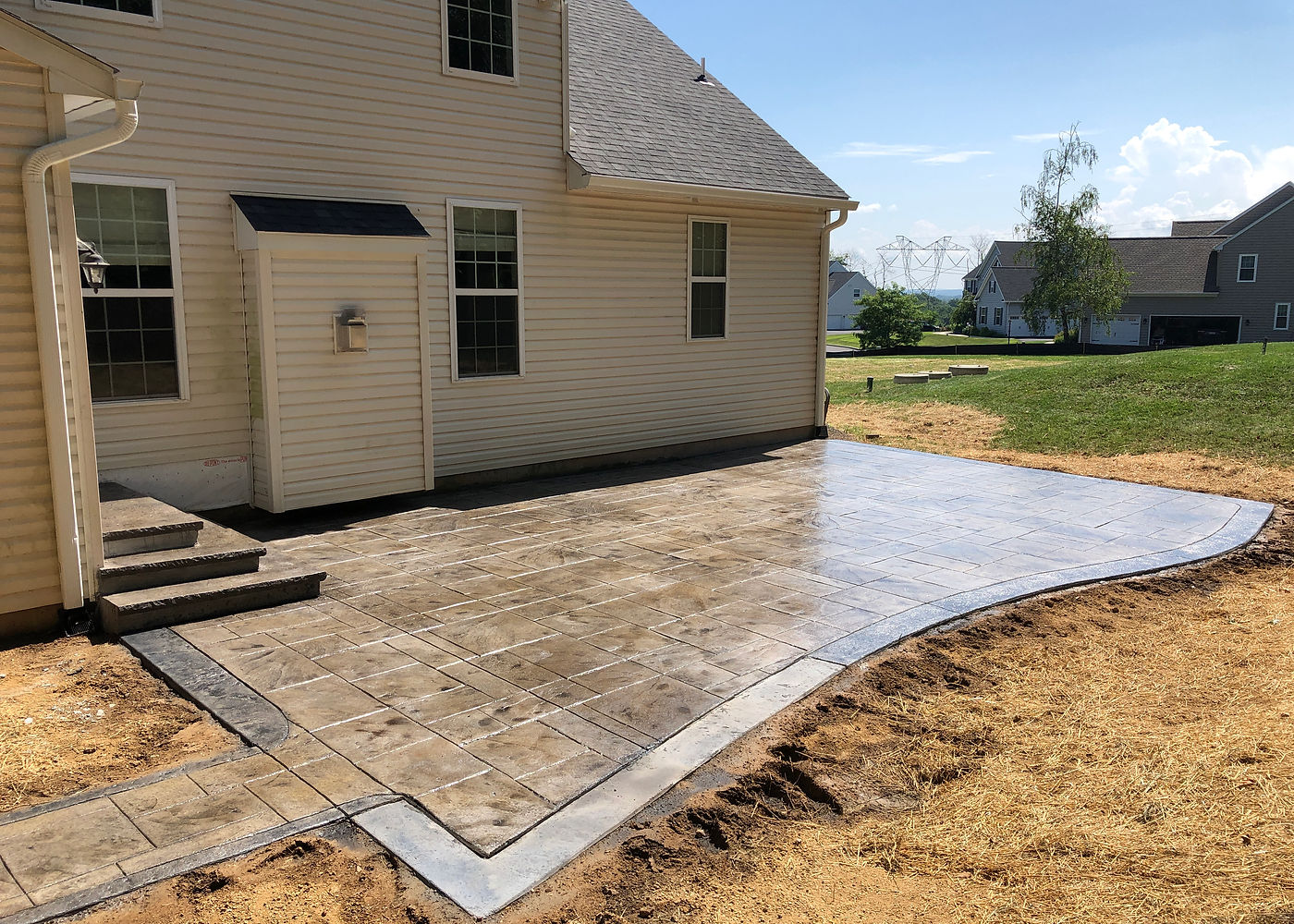 Finished Amanda S stamped concrete patio behind the home by ASRE
